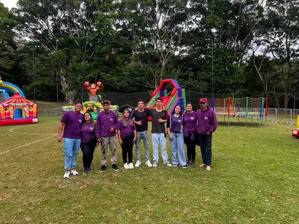 Equipe da Festa Top com camisetas roxas em frente aos brinquedos montados